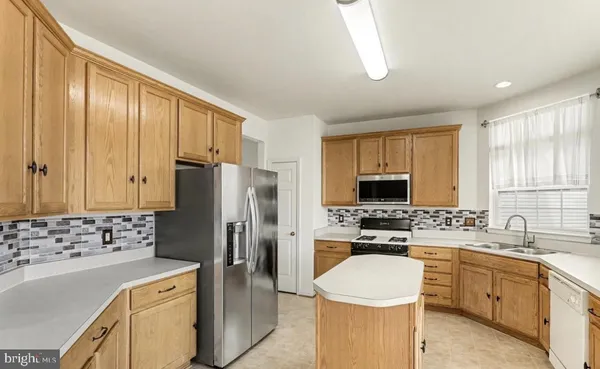 a kitchen with a refrigerator stove top oven and sink
