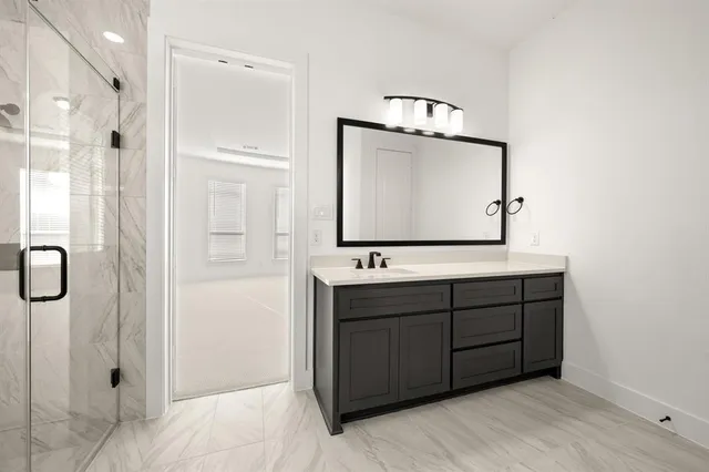 a bathroom with a sink vanity mirror and shower