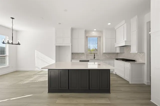 a kitchen with a sink cabinets and wooden floor