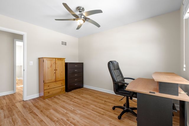 a view of a workspace with furniture and wooden floor