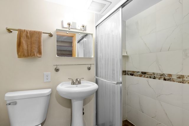a bathroom with a sink mirror and toilet