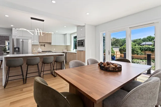 a kitchen with a table chairs and wooden floor