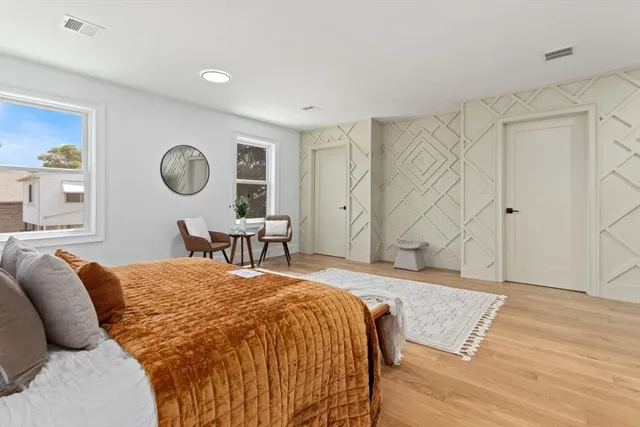 a bed room with a bed and painting on the wall