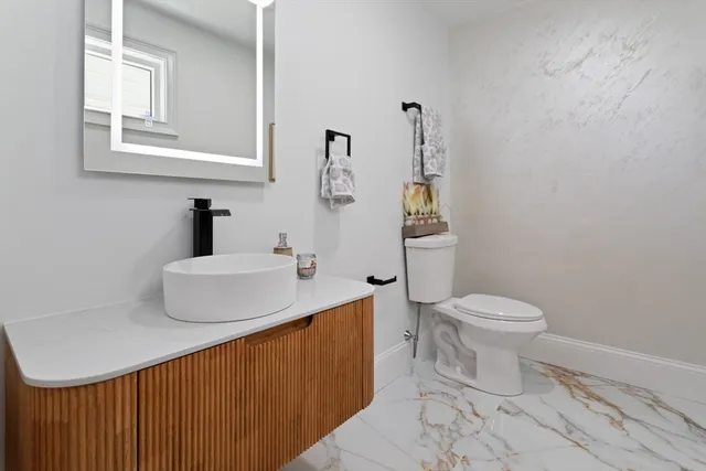 a bathroom with a sink toilet and mirror