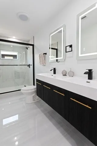 a spacious bathroom with a double vanity sink a mirror and a bathtub