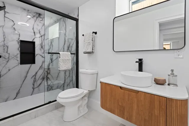 a bathroom with a sink a toilet and mirror