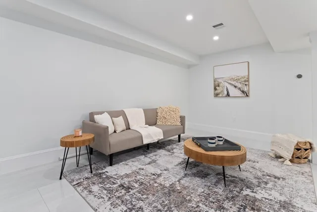 a living room with furniture a rug and a wall painting