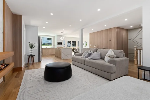 a living room with furniture a large window with kitchen view
