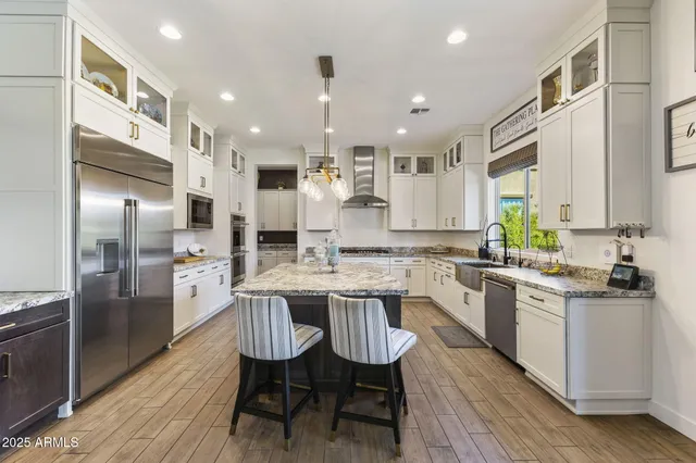 a kitchen with granite countertop kitchen island stainless steel appliances a sink stove and refrigerator