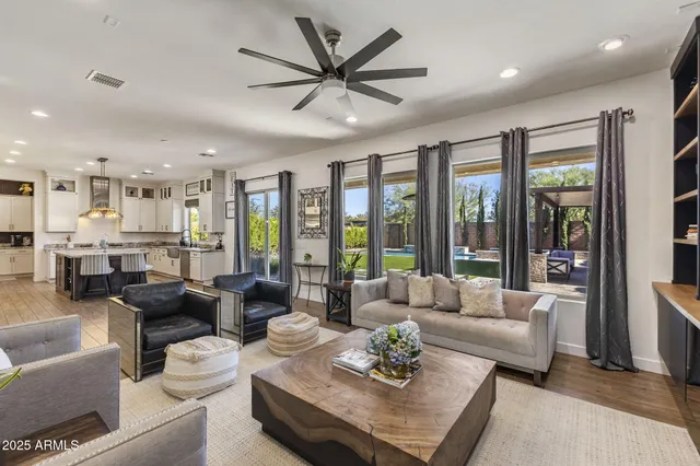 a living room with furniture kitchen view and a large window
