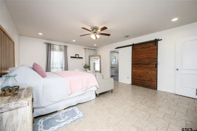 a spacious bedroom with a bed and a ceiling fan