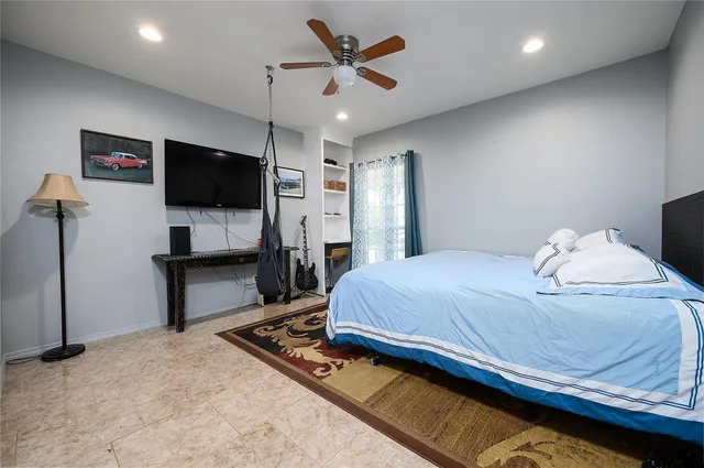 a bedroom with a bed a flat screen tv and a couch