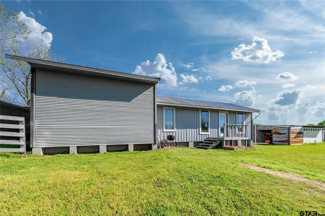 a view of a house with patio next to a yard