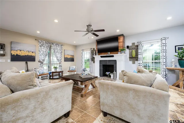 a living room with furniture a fireplace and a flat screen tv