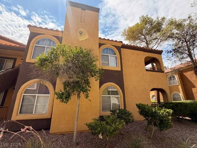 7950 West Flamingo Road, Unit 2142 Las Vegas, NV 89147 - Photo 1 of 3 Multi-level facade with charming archways, an inviting balcony, and verdant landscaping.