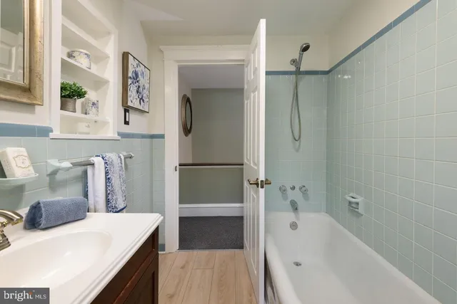 a bathroom with a tub sink and a mirror