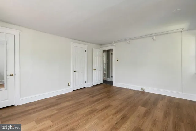 a view of an empty room with wooden floor