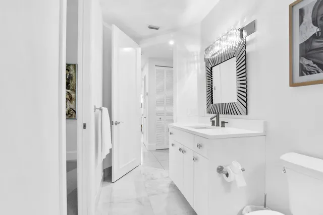 a bathroom with a sink a toilet and a mirror