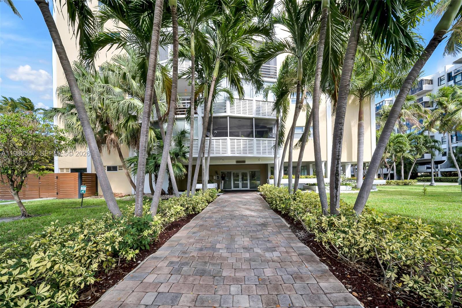 555 Crandon Boulevard, Unit 53 Key Biscayne, FL 33149 - Photo 21 of 23 a front view of a house with a yard and potted plants