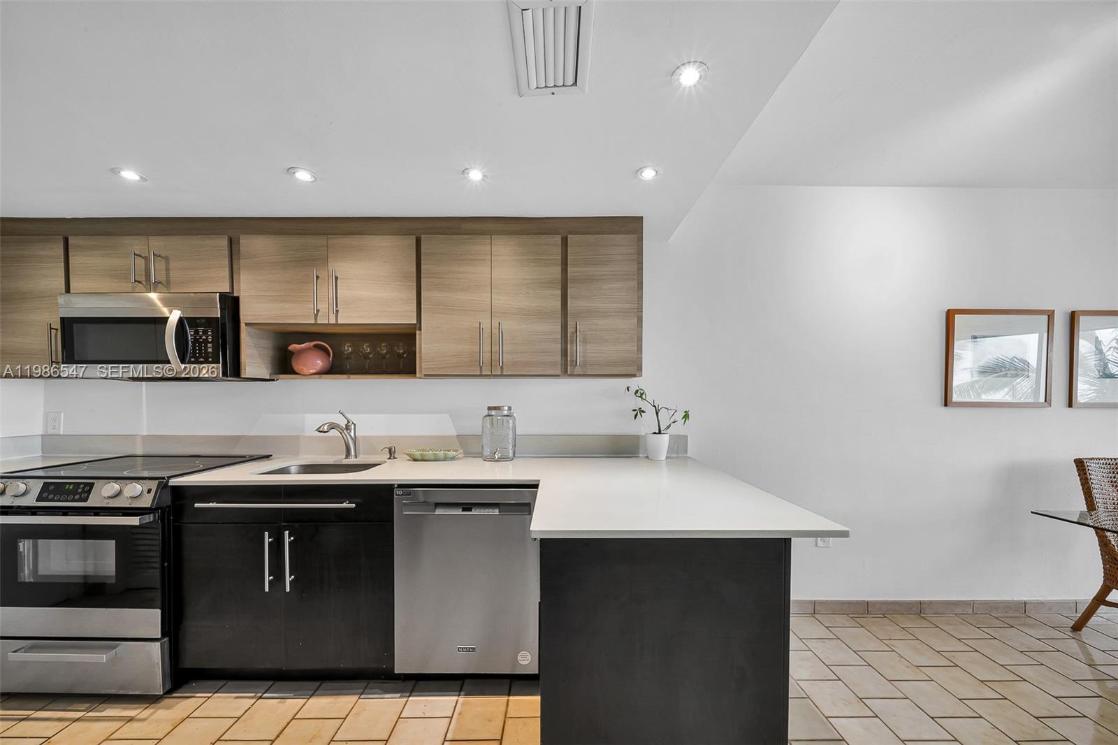 555 Crandon Boulevard, Unit 53 Key Biscayne, FL 33149 - Photo 7 of 23 a kitchen with stainless steel appliances a sink a stove a microwave a center island and cabinets