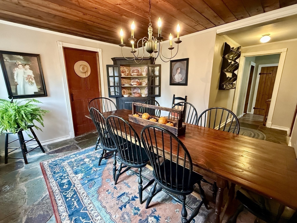 a dining room with furniture potted plants and wooden floor