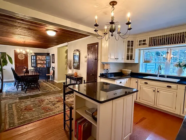 a kitchen with granite countertop a sink appliances cabinets and dining table