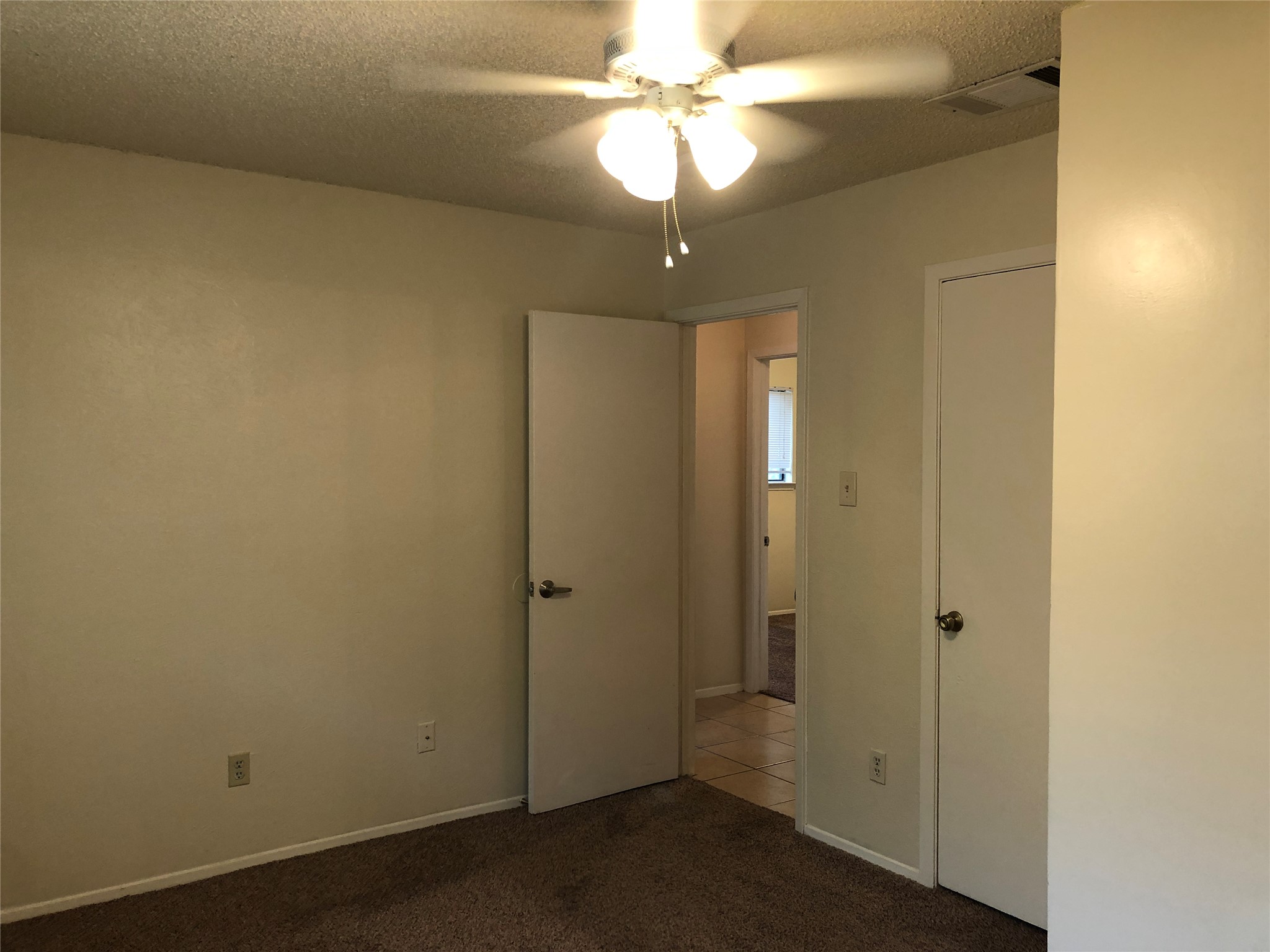 11510 Walnut Ridge Drive, Unit B Austin, TX 78753 - Photo 9 of 18 Plush carpeting anchors this versatile room with dual doorways and neutral-toned walls.