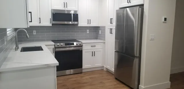 a kitchen with a refrigerator stove and sink