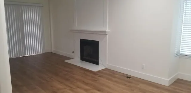 a view of a room with wooden floor and fireplace