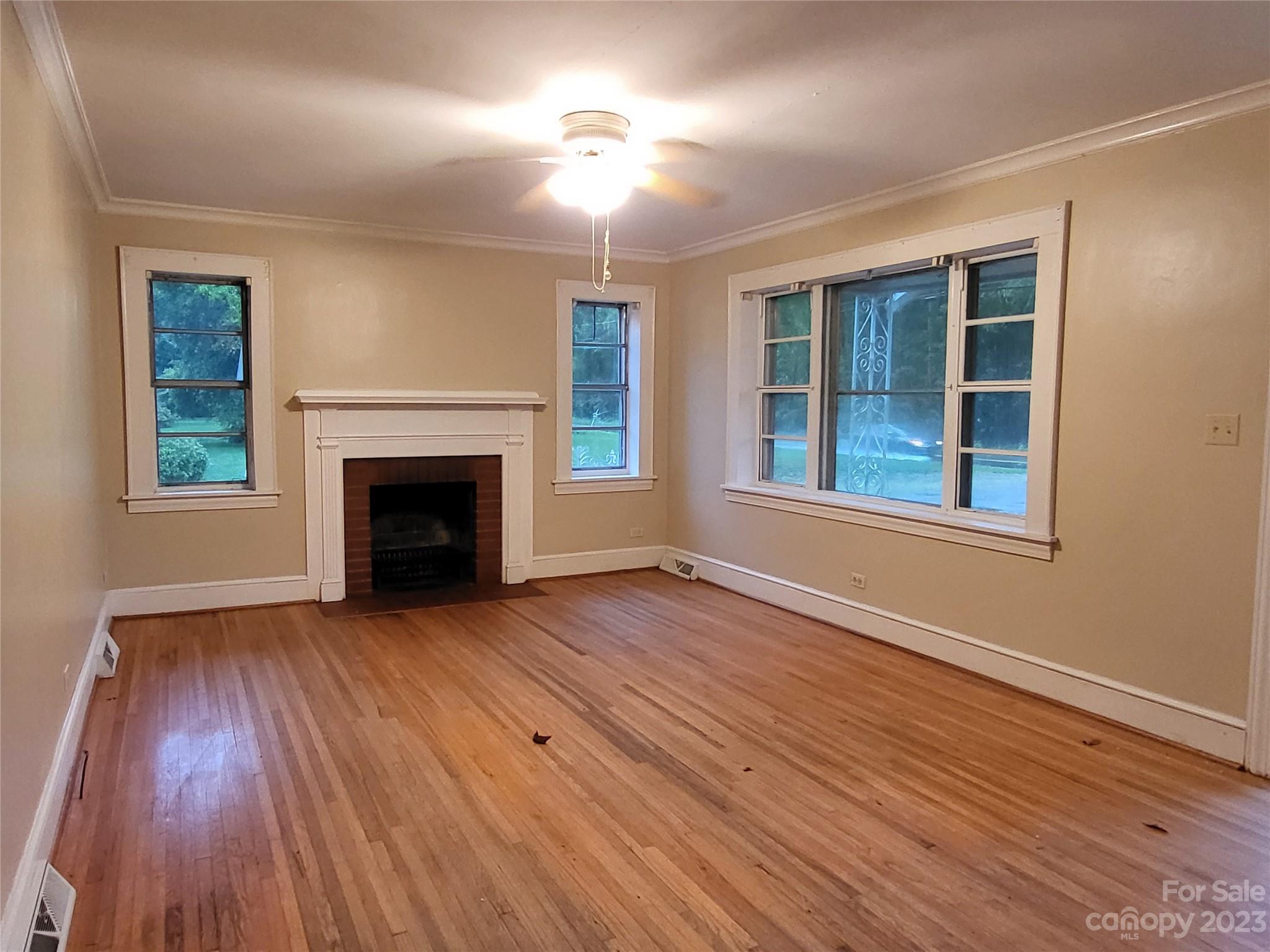 708 Tom Sadler Road Charlotte, NC 28214 - Photo 5 of 16 a view of an empty room with wooden floor fireplace and a window