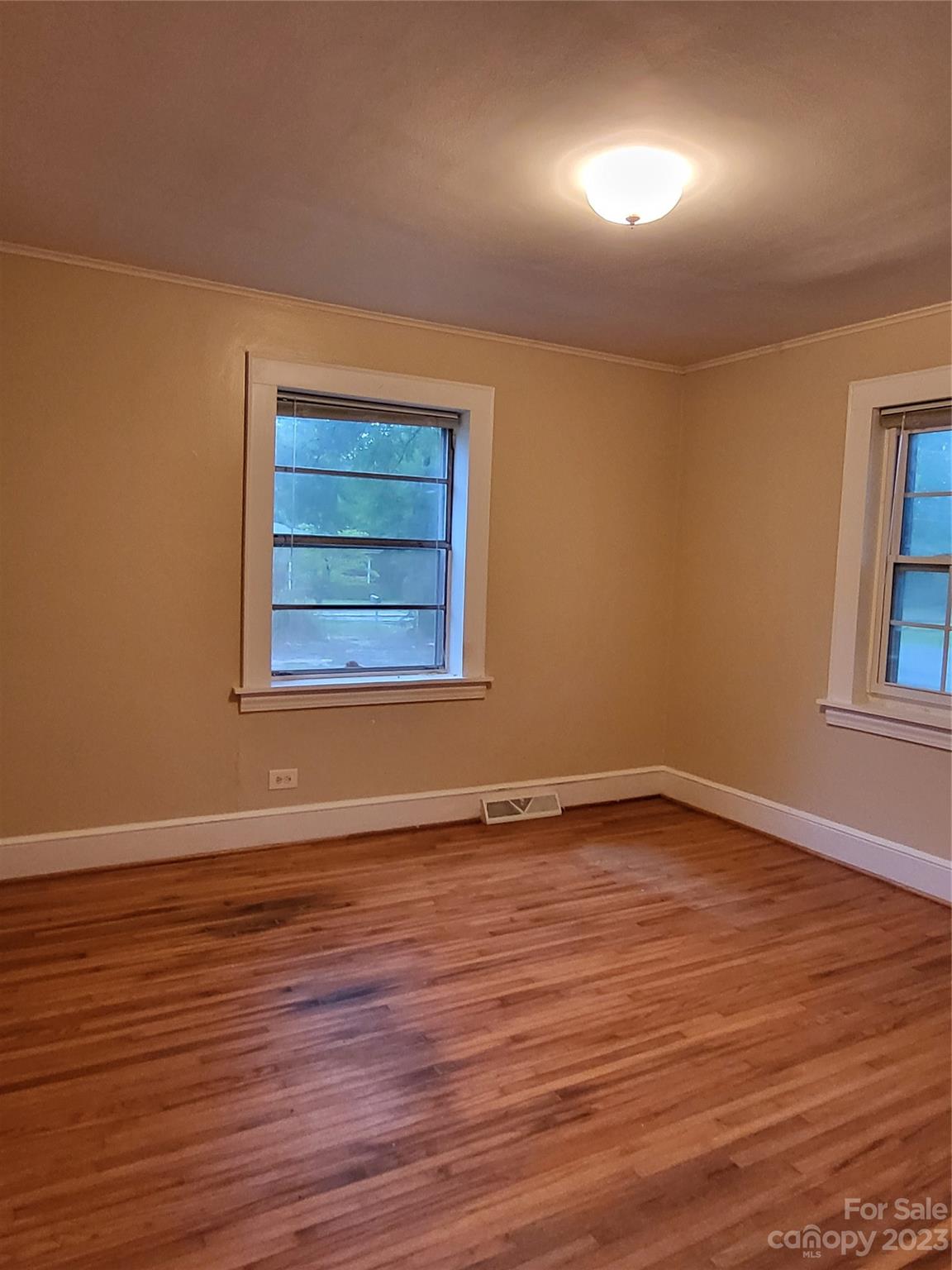 708 Tom Sadler Road Charlotte, NC 28214 - Photo 6 of 16 a view of an empty room with wooden floor and a window