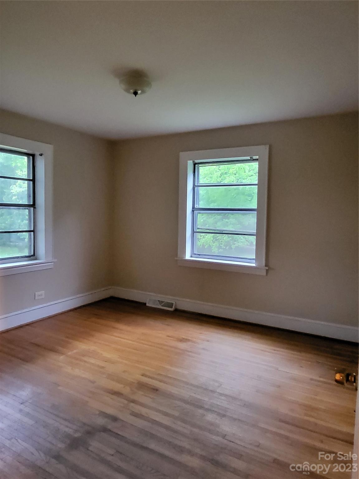 708 Tom Sadler Road Charlotte, NC 28214 - Photo 8 of 16 an empty room with wooden floor and windows