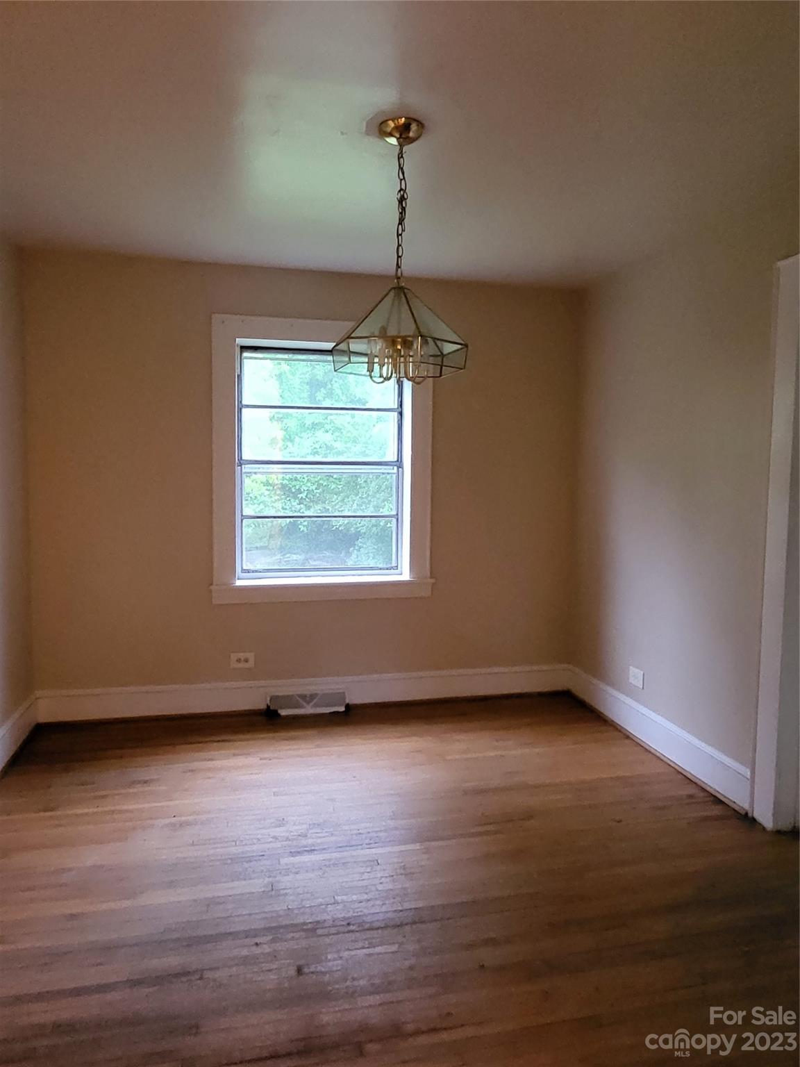 708 Tom Sadler Road Charlotte, NC 28214 - Photo 9 of 16 a view of an empty room with wooden floor and a window