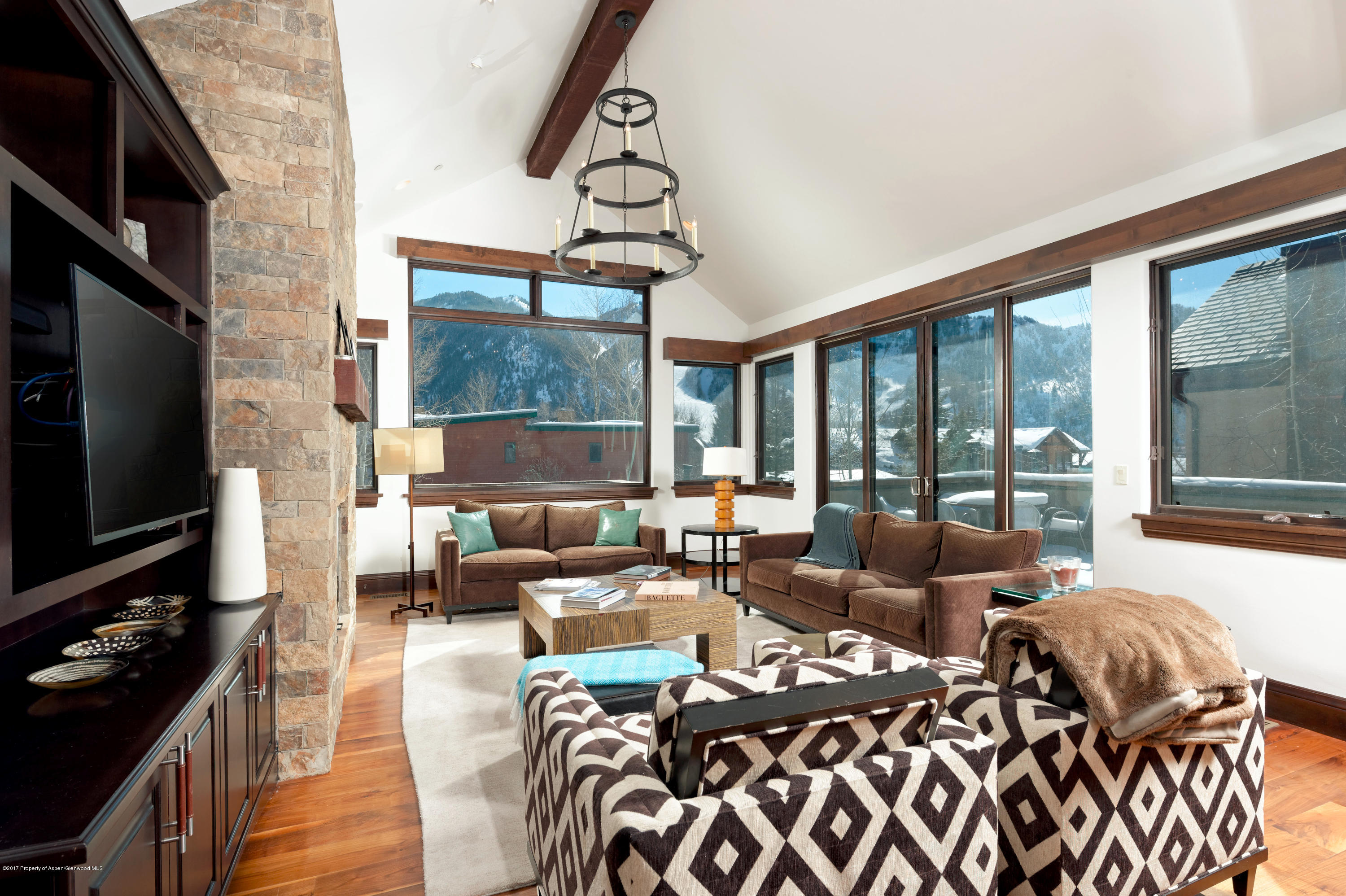 566 Race Street Aspen, CO 81611 - Photo 3 of 26 a living room with furniture a flat screen tv and a floor to ceiling window