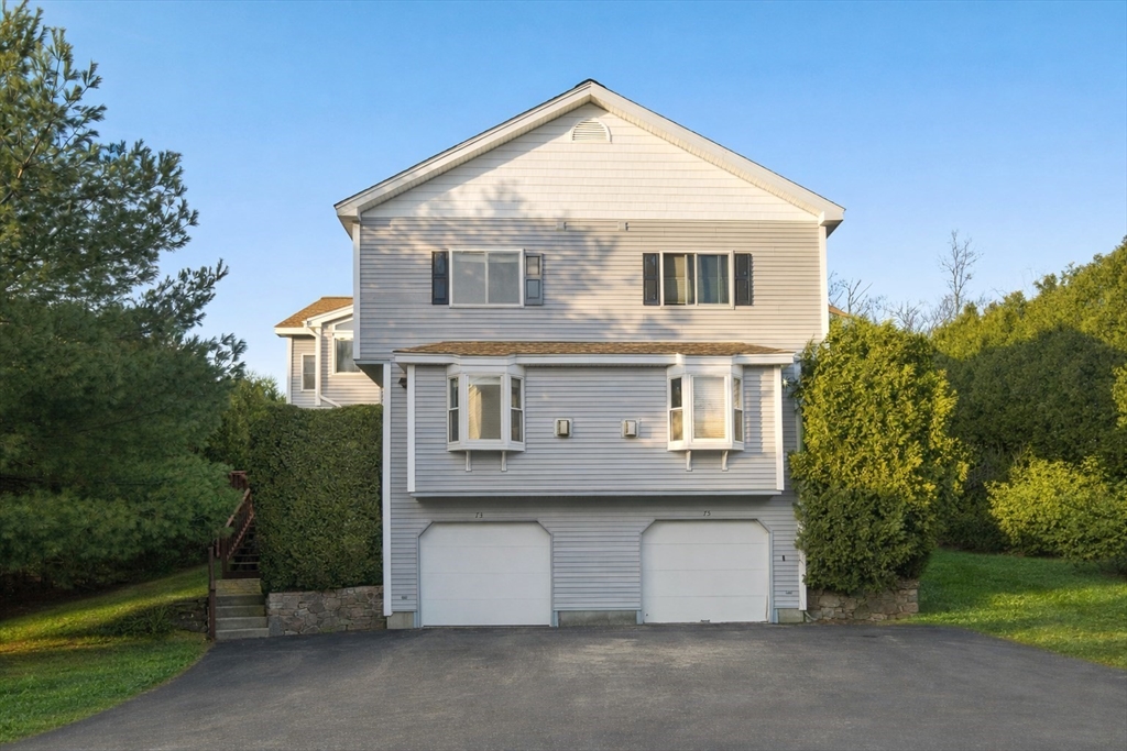 73 Half Crown Circle, Unit 73 Ashland, MA 01721 - Photo 1 of 25 a front view of a house with a yard and garage