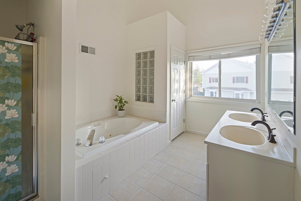 73 Half Crown Circle, Unit 73 Ashland, MA 01721 - Photo 13 of 25 a bathroom with a tub a sink a window and a shower