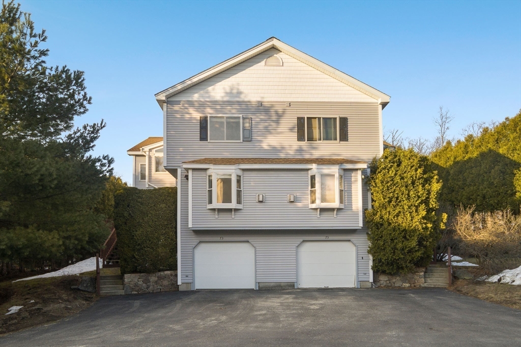 73 Half Crown Circle, Unit 73 Ashland, MA 01721 - Photo 22 of 25 a view of a white house with large windows and a yard