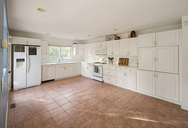 a kitchen with white cabinets and white appliances