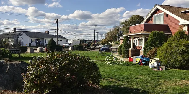 a view of a house with a big yard and large trees