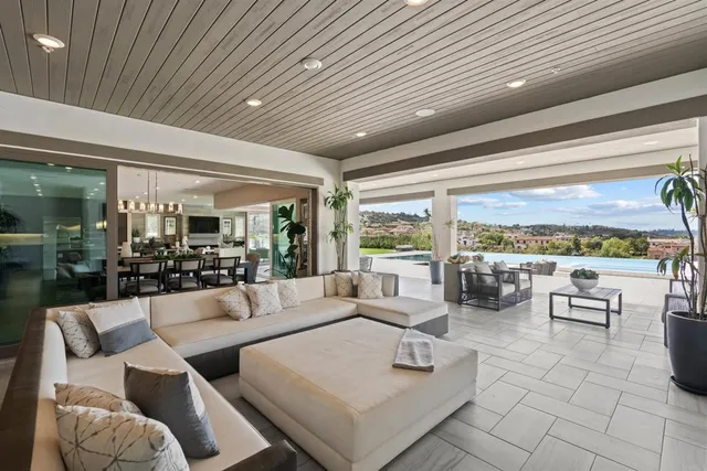 a living room with furniture a flat screen tv and kitchen view