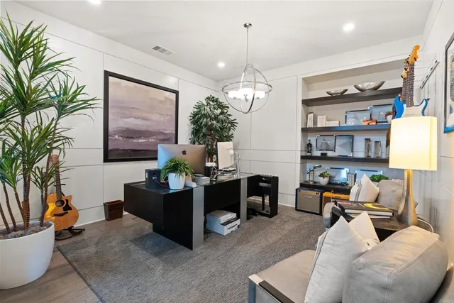 a living room with furniture large window and wooden floor