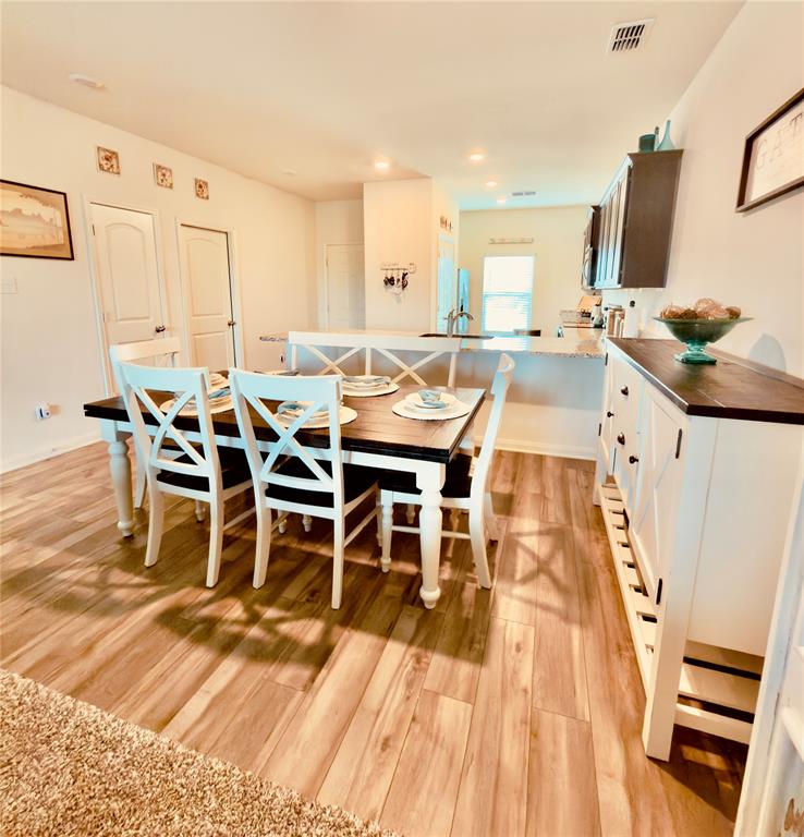 196 Cattlemans Crk Road West Newark, TX 76071 - Photo 4 of 24 Dining area with wood-finish flooring, recessed lighting, and a white breakfast bar with a decorative X-patterned facade