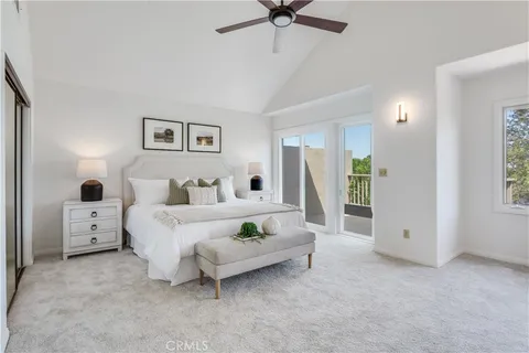 a spacious bedroom with a bed and glass walk in closet