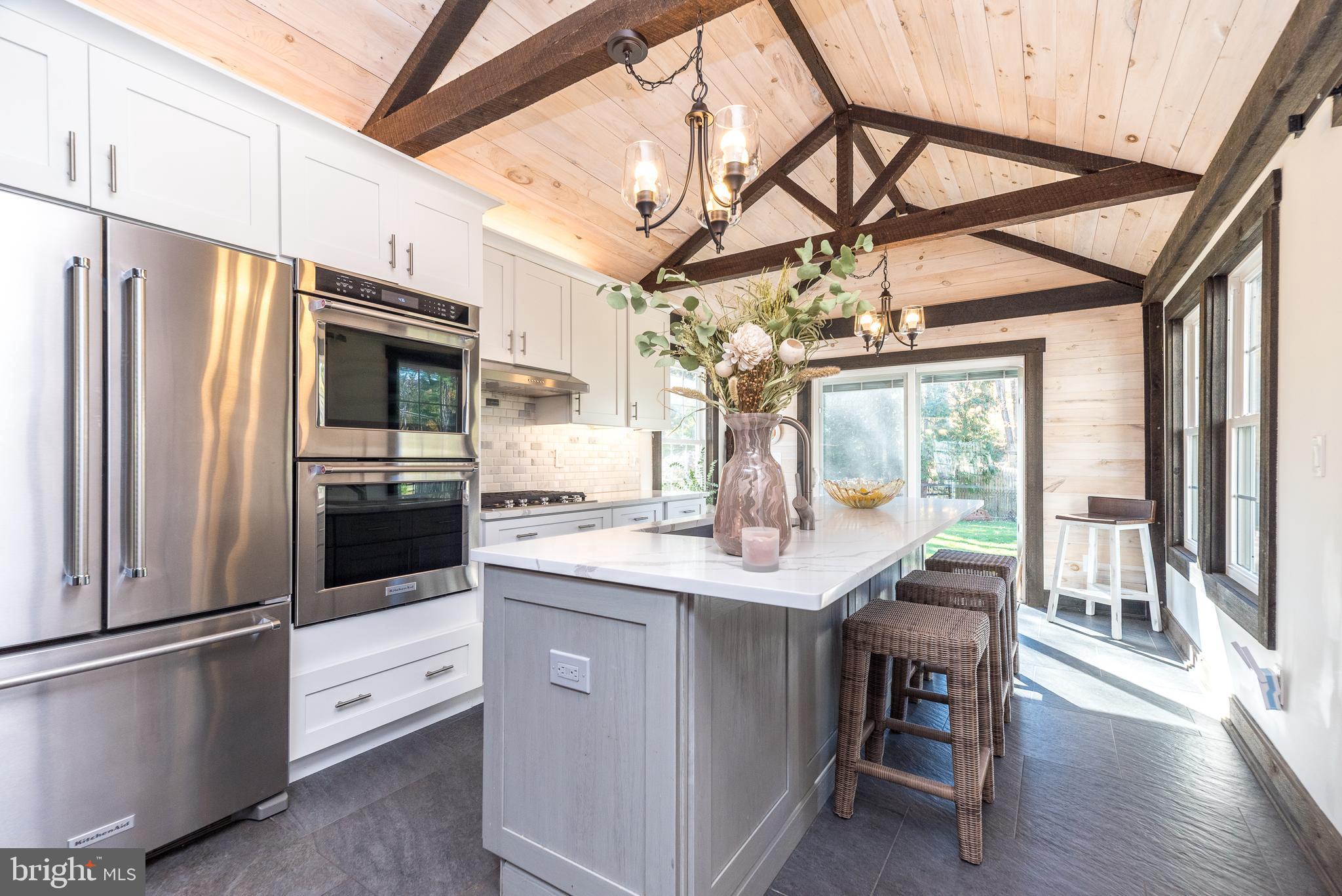 1442 River Road Upper Black Eddy, PA 18972 - Photo 12 of 65 a kitchen with stainless steel appliances a table chairs and chandelier