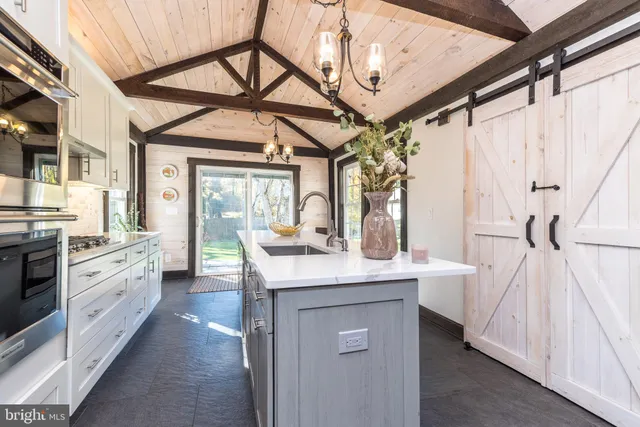 a kitchen with stainless steel appliances granite countertop a sink a stove and cabinets