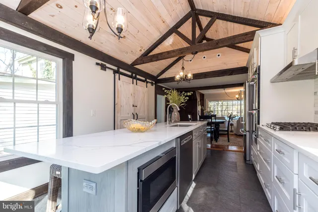 a large kitchen with a large window and stainless steel appliances