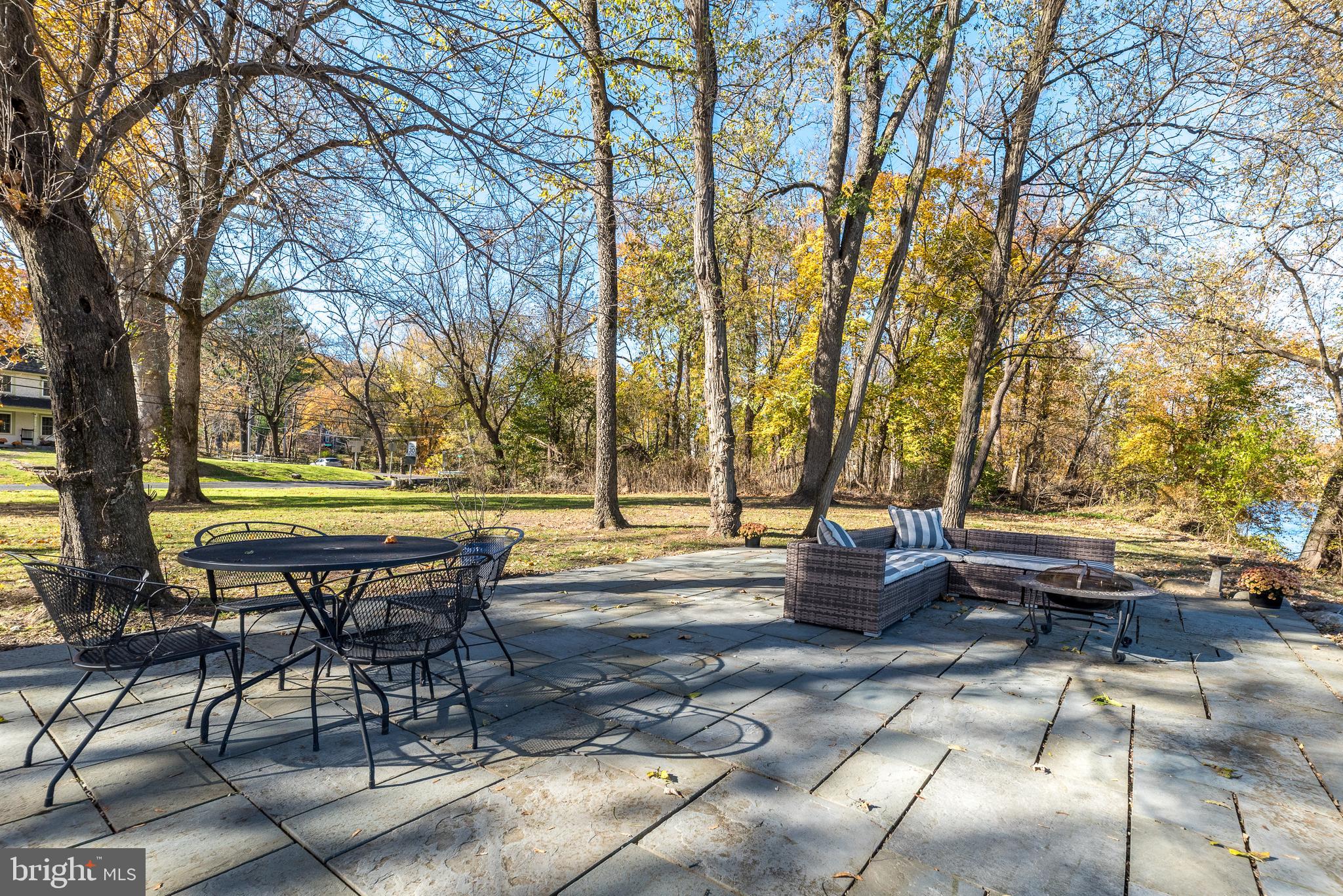 1442 River Road Upper Black Eddy, PA 18972 - Photo 46 of 65 a backyard view with table and chairs couches and a fire pit