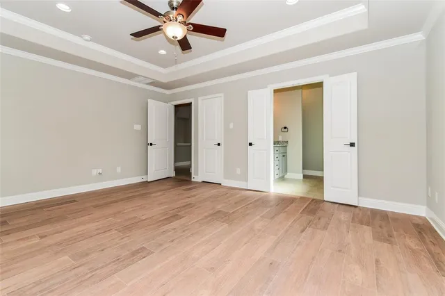 a view of an empty room and chandelier fan