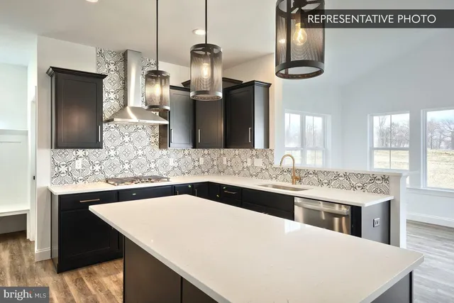 a kitchen with stainless steel appliances kitchen island granite countertop a sink a stove and refrigerator