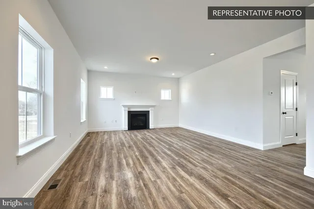 a view of empty room with wooden floor and fireplace